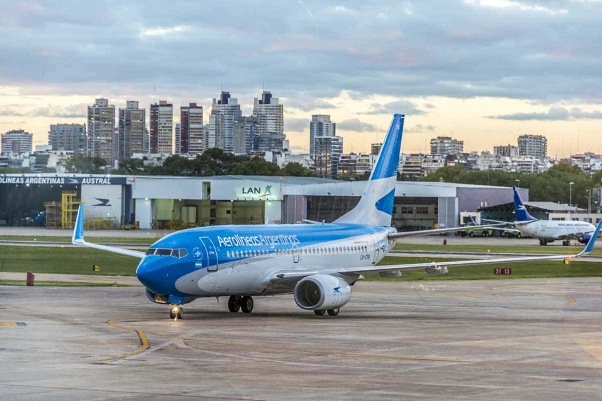 Foto de um avião, céu azul taxiando na pista