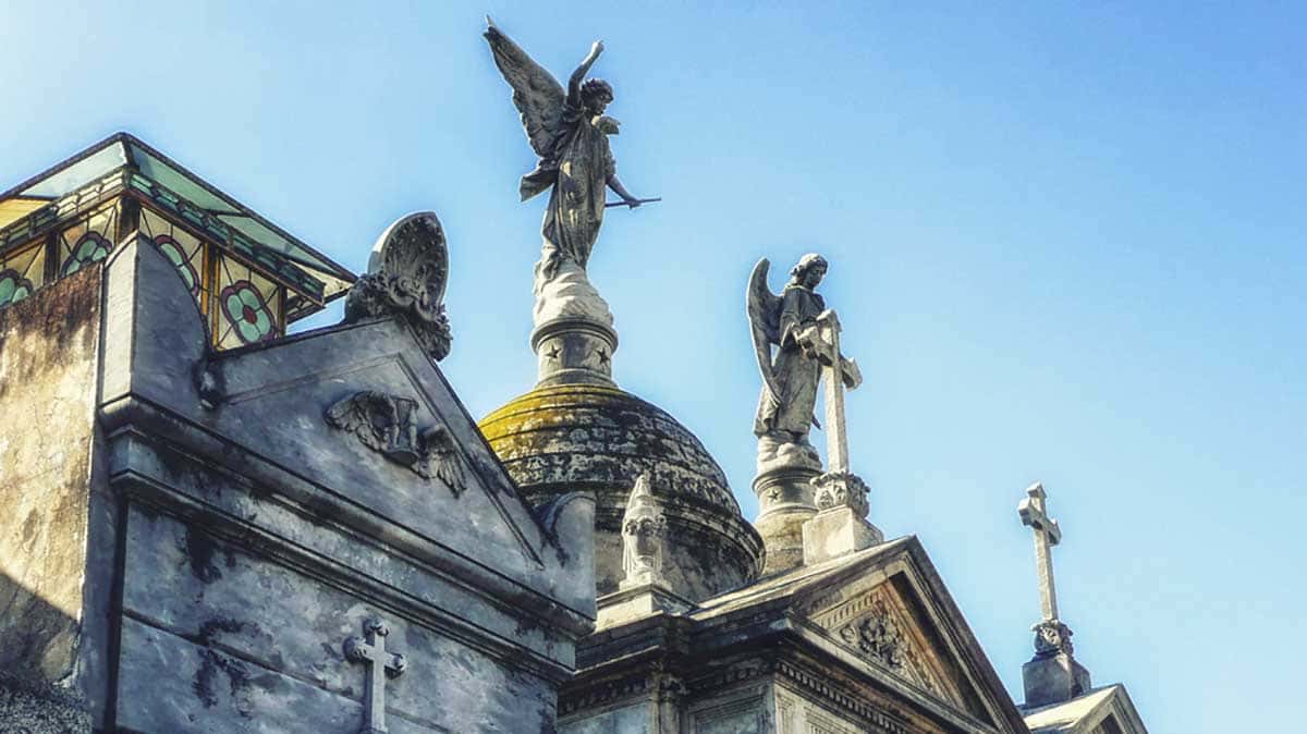 Estátuas de anjos no topo de tumbas em um cemitério
