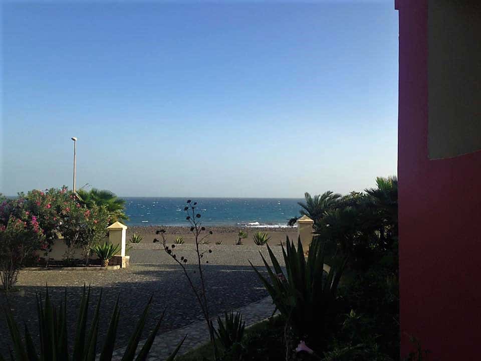Vista de resort em Cabo Verde mostra parte de uma janela e o mar