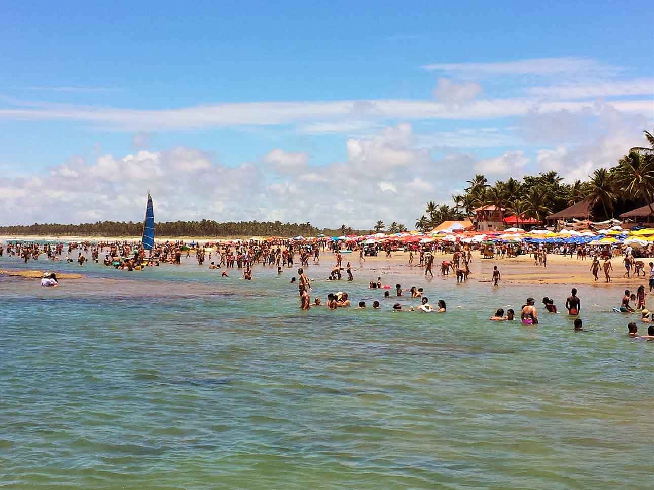 Praia, pessoas em piscinas naturais, faixa de areia e barracas: onde ir em Maceió
