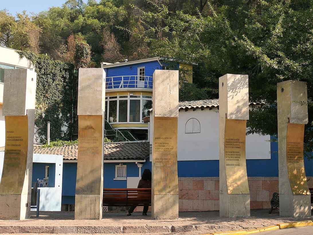 Três colunas de pedra e uma casa em azul e branco ao fundo: o que fazer em Santiago