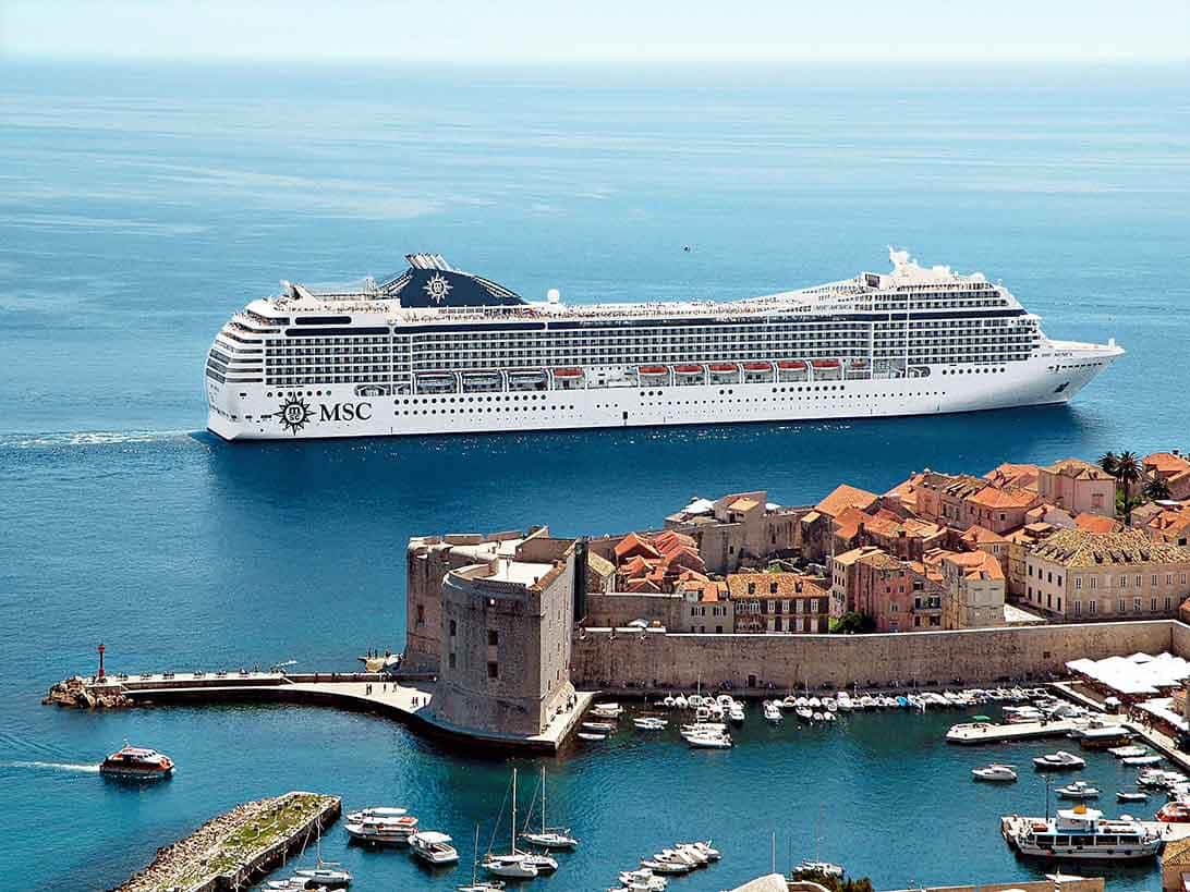 Navio e muralhas de Dubrovnik. O navio estará em cruzeiros marítimos no Brasil 