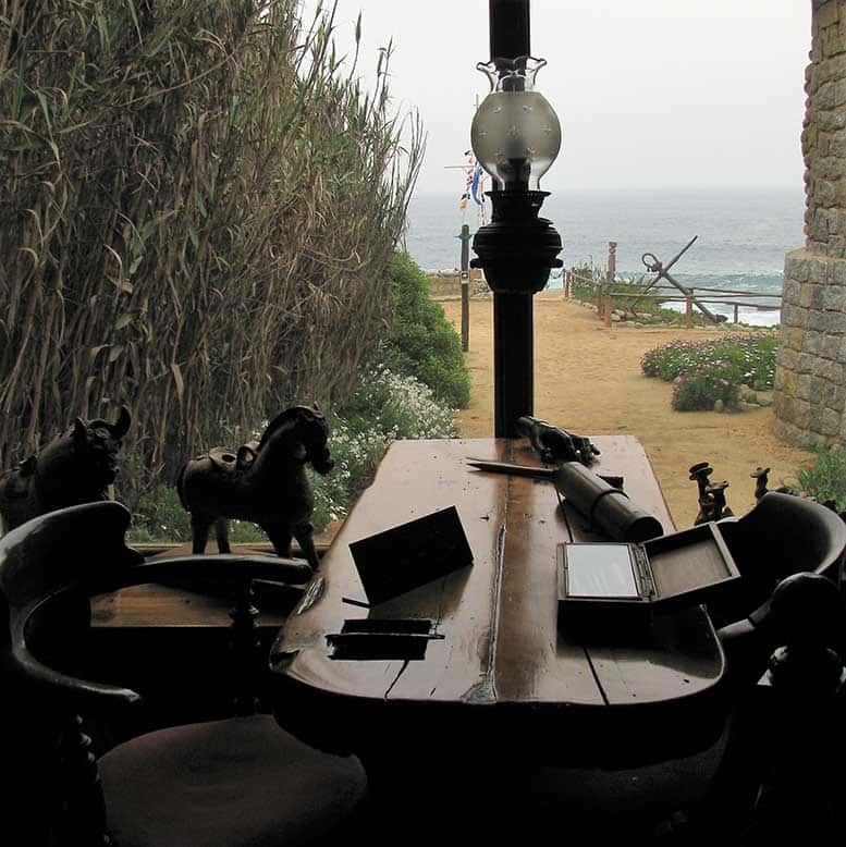 Mesa com cadeiras e o mar ao fundo em Isla Negra