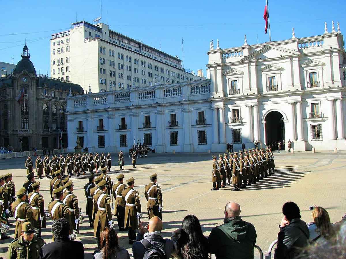 Pessoas assistem à troca de guarda em frente a Palacio La Moneda em um dos programas turísticos que dá pra fazer em Santiago