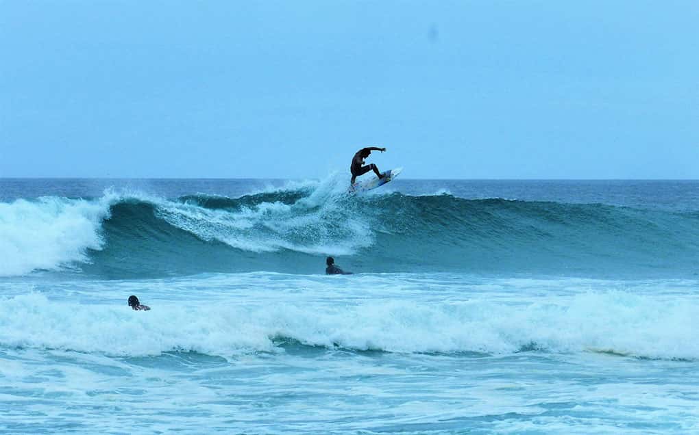 Rapazes surfam nas ondas da Praia Grande, uma das praias de Arraial do Cabo