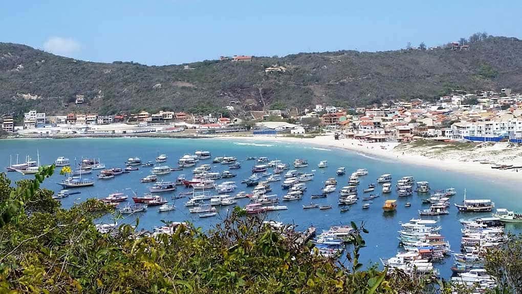 Vegetação, Barcos na praia, casas e morros na praia dos Anjos, uma das praias de Arraial do Cabo
