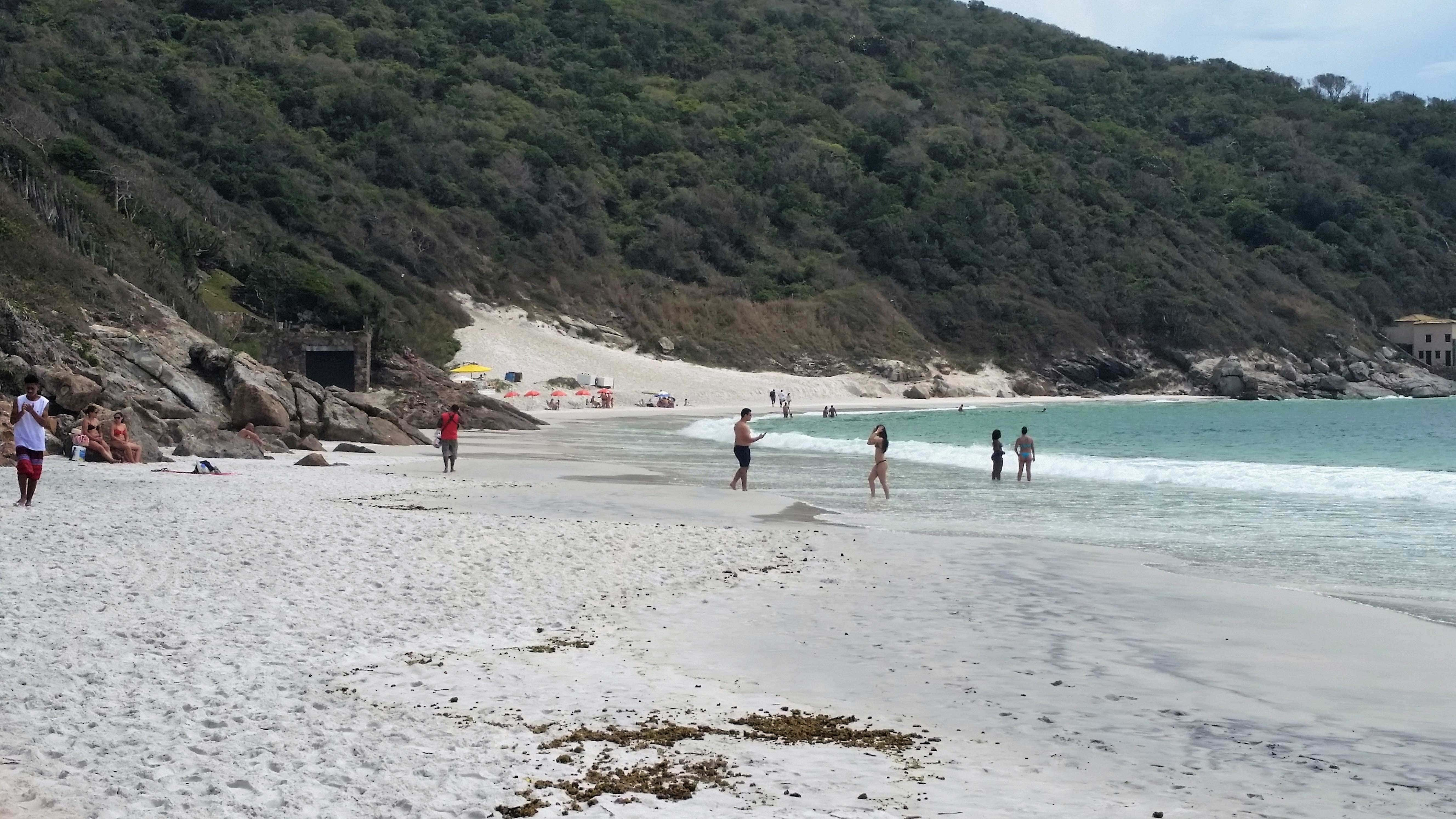 Praia com pessoas, chamada Prainhas do Atalaia