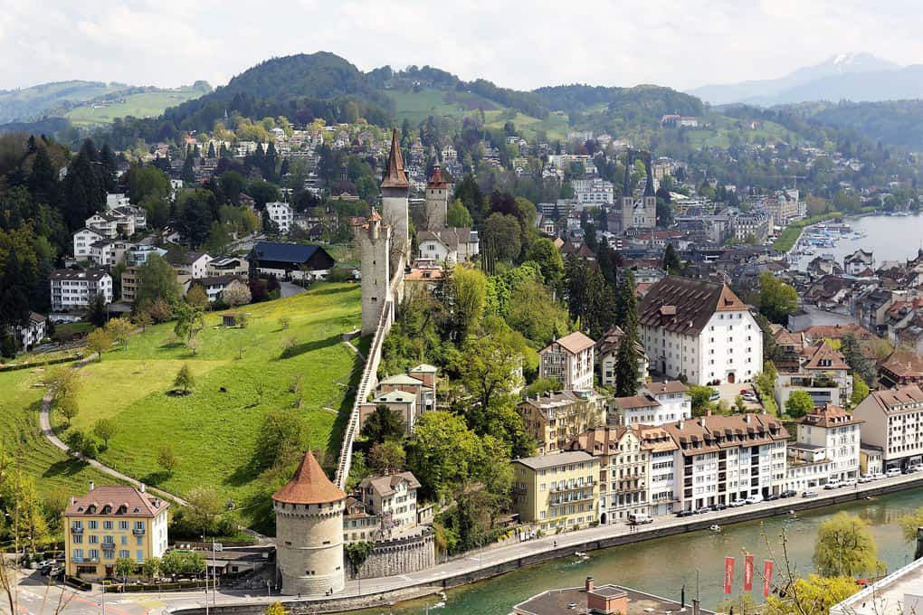 Vista da cidade de Lucerna, com destaque para casas à beira do rio e a muralha da cidade antiga