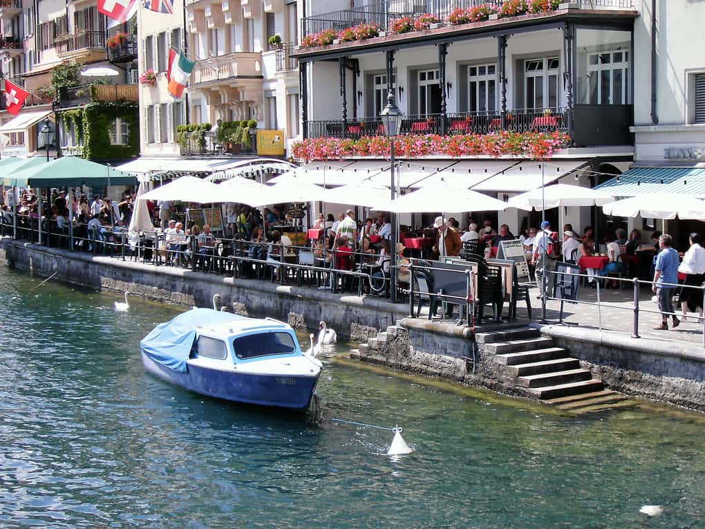 Rio, barco, restaurantes e casario antigo em Lucerna, na Suíça