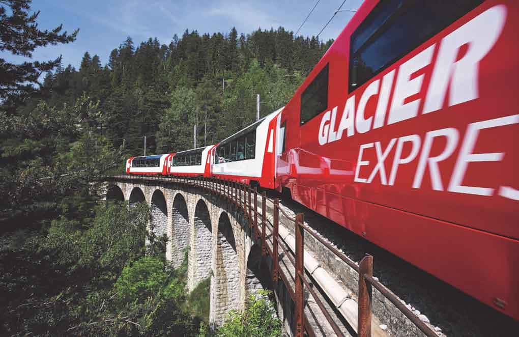 Trem passando sobre ponte em paisagem suíça