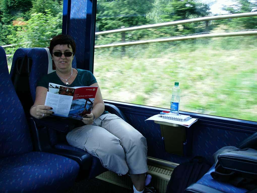 Moça sentada em poltronas em vagão de trem na Suíça