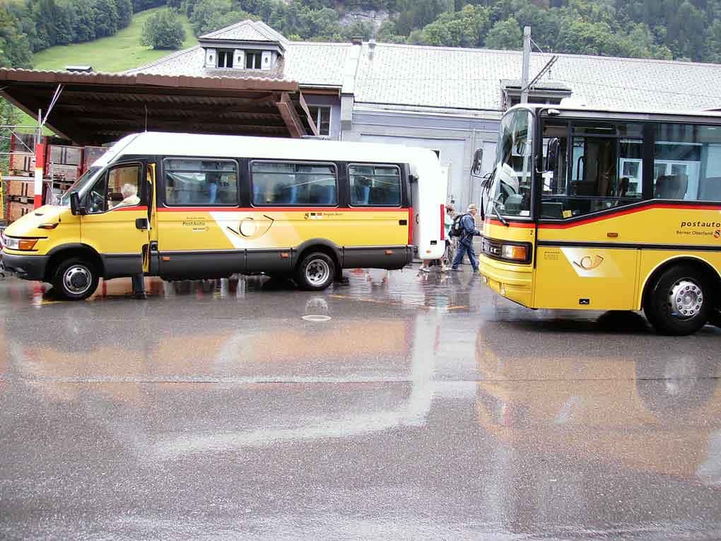Dois ônibus nas cores amarela fazem parte do sistema de transporte na Suíça