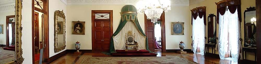 Sala com um trono imprial ao meio e vários móveis pertencente ao Museu Imperial de Petrópolis