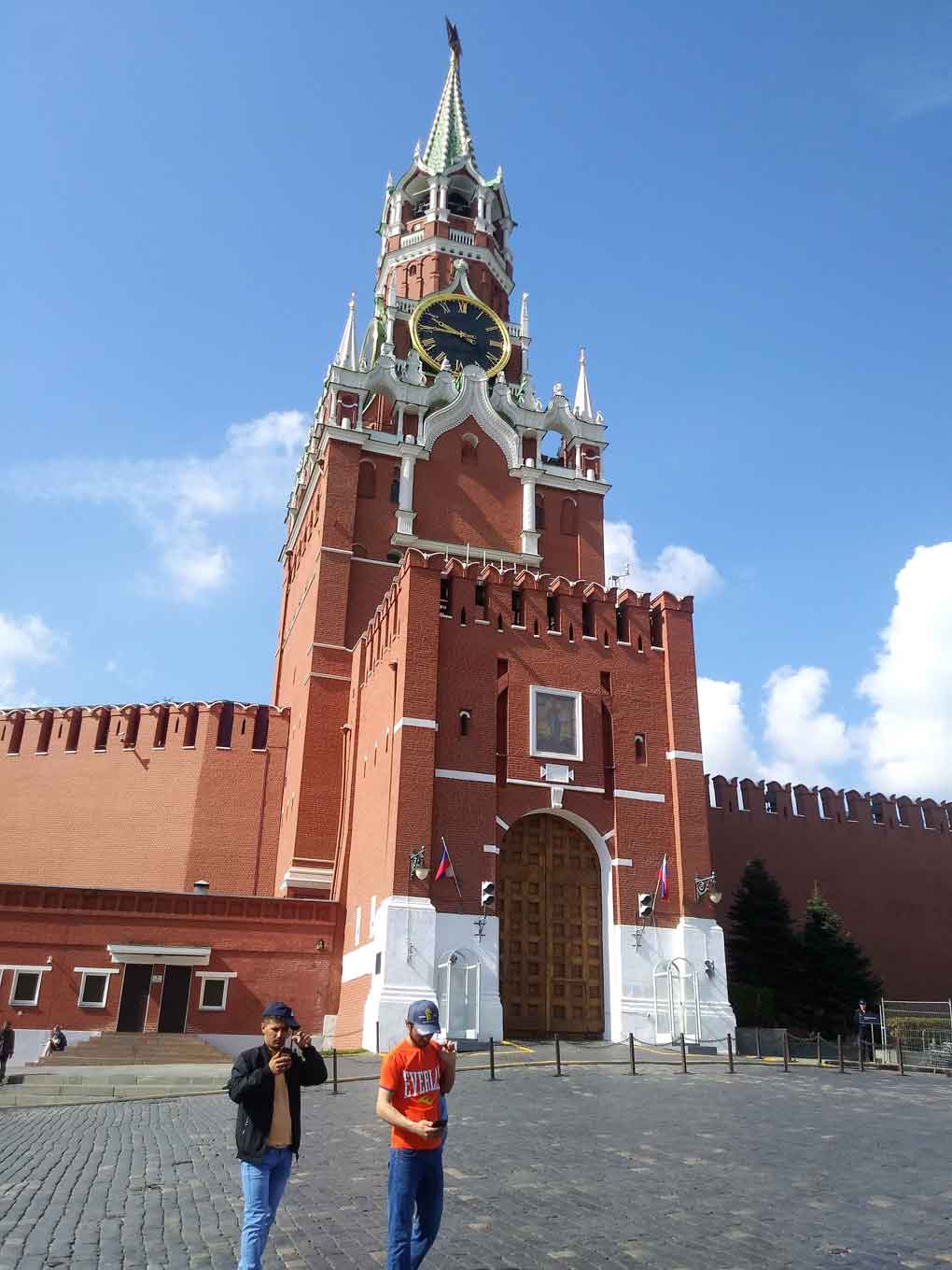 Torre na cor vermelha, com detalhes em branco e turistas na frente